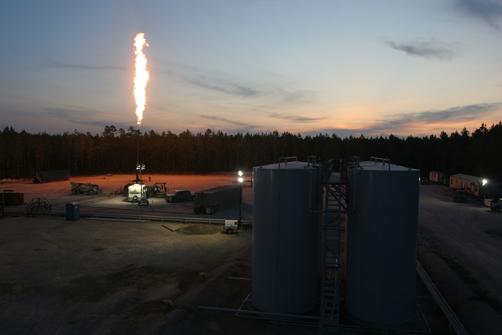 Field equipment and a gas flare at dusk